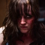 Brooklyn Horror Film Festival 2026 — a blood-spattered woman with wet hair stares down the camera in a still from the 2026 program